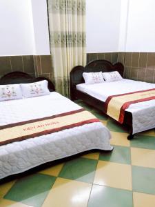 two beds sitting next to each other in a room at Kiến An Hotel Cần Thơ in Can Tho