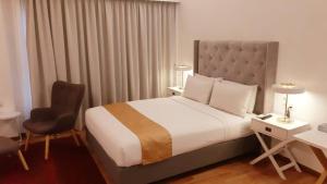 a hotel room with a bed and a desk and a chair at The Boutique Residence Hotel in George Town