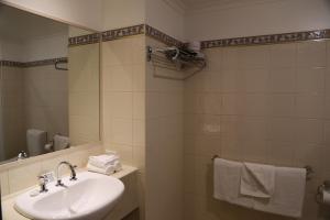 a bathroom with a sink, mirror, and towel rack at Wentworth Grande Resort in Wentworth
