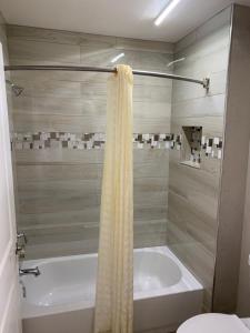 y baño con bañera y ducha con cortina de ducha. en SouthTown S.A. Inn, en San Antonio