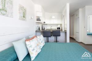 a bedroom with a bed and a kitchen with white cabinets at Alojamiento Alby: Oceano in Los Cristianos