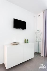 a white cabinet with a television on a wall at Alojamiento Alby: Oceano in Los Cristianos