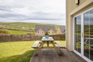 a picnic table with a vase of flowers on a patio at Cois Chnoic in Dingle