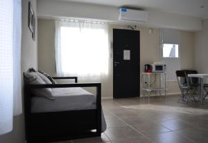 Un dormitorio con una cama y una cocina y una mesa. en Florencia Departamentos, en Tandil 15 fotos más