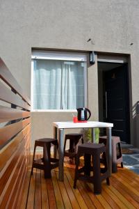 una mesa y sillas en una terraza con ventana en Florencia Departamentos en Tandil
