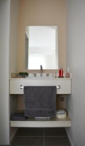 un baño con lavabo y espejo en Florencia Departamentos, en Tandil