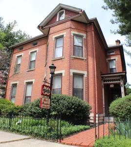 une maison en briques rouges avec un panneau devant elle dans l'établissement 50 Lincoln Short North Bed & Breakfast, à Columbus