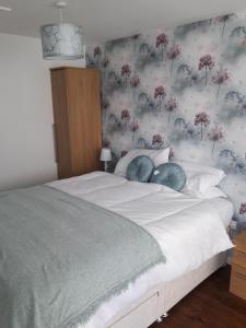 1 dormitorio con 1 cama y papel pintado con motivos florales en Bell Inn en Evesham