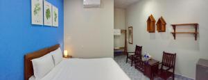 a bedroom with a bed and two chairs in it at Eden House & Coffee Con Dao in Con Dao