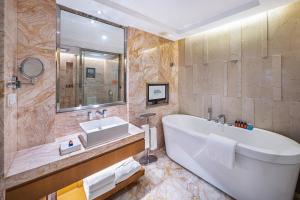 ein Badezimmer mit einer großen Badewanne und einem Waschbecken in der Unterkunft Galaxy minyoun Chengdu Hotel in Chengdu