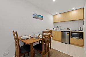 a kitchen with a wooden table and chairs in a room at Queenstown Lake Views - Downstairs Apartment in Queenstown