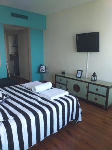 a bedroom with a black and white striped bed and a television at Gran vista desde el centro de la ciudad in Buenos Aires