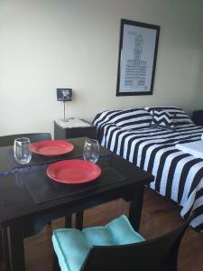 a dining room with two beds and a table with red plates at Gran vista desde el centro de la ciudad in Buenos Aires