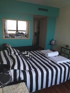 a bedroom with a black and white striped bed at Gran vista desde el centro de la ciudad in Buenos Aires