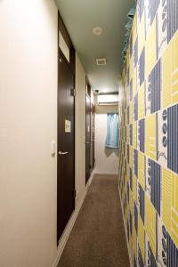 a hallway with yellow and blue tiles on the wall at Hotel Owl Tokyo Shinbashi in Tokyo
