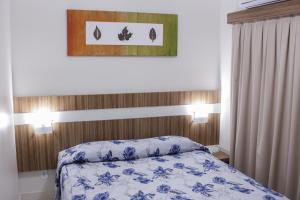 a bedroom with a bed with a blue and white comforter at Lacqua diRoma com ABD-TURISMO- Hotéis e Parques uma DIVERSÃO GARANTIDA in Caldas Novas