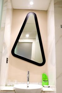 a mirror above a sink in a bathroom at MaxOneHotels @Balikpapan in Balikpapan +46 photos