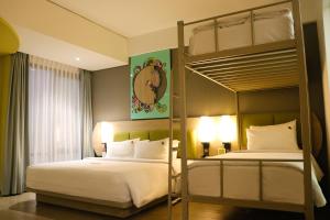 1 dormitorio con 2 camas y 1 litera en MaxOneHotels @Balikpapan, en Balikpapan