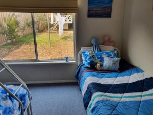 a small bedroom with a bed and a window at Little Port Cottage in Portarlington