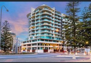 a large apartment building with a lot of windows at Glenelg Getaway 3 bedroom apartment when correct number of guests are booked in Glenelg