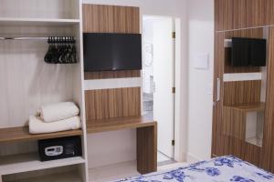 1 dormitorio con 1 cama y TV en una habitación en Lacqua diRoma com ABD-TURISMO- Hotéis e Parques uma DIVERSÃO GARANTIDA, en Caldas Novas