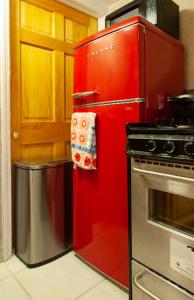 a red refrigerator in a kitchen next to a stove at Studio Apartment in Irvington