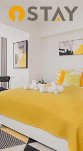 a bedroom with a large bed with a yellow blanket at Hotel Apartment Ueno Inaricho Sta in Tokyo