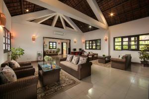 uma grande sala de estar com sofás e uma mesa em Son Tra Resort & Spa Danang em Da Nang