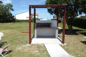a barbecue grill in a yard with a canopy at Complejo Miranieves, se alquila casa para 5 personas en Miramar Costa Atlantica in Miramar