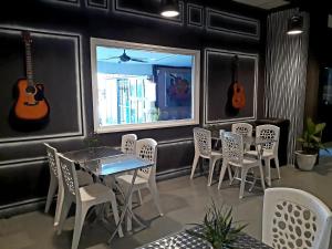 Dorm Master في كامبونغ بادانغ ماسير: مطعم على الجدار طاولة وكراسي وقيادات
