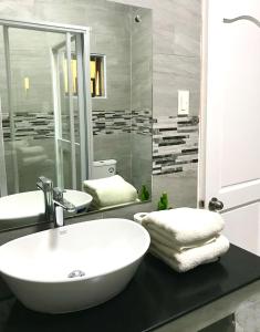 een badkamer met een witte wastafel en een spiegel bij Nora's Place in Panglao