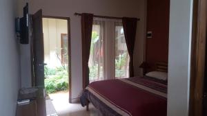 a bedroom with a bed and a window at Aloha Hotel Yogyakarta in Yogyakarta