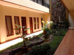 a courtyard of a building with plants in it at Aloha Hotel Yogyakarta in Yogyakarta