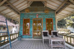 una pequeña casa con una mesa y sillas en un porche en Segar Village, en Gili Air