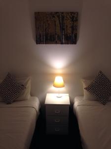 
a bedroom with a bed and a lamp at Abel Tasman Airport Motor Inn in Launceston
