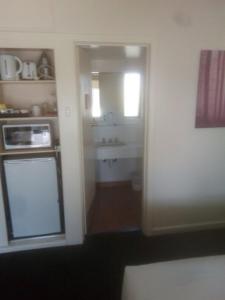 
a kitchen with a sink and a refrigerator at Abel Tasman Airport Motor Inn in Launceston
