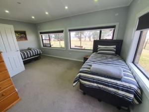 a bedroom with a bed and two windows at Pleasant Hill BnB in Mount Gambier