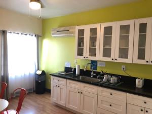 a kitchen with white cabinets and a sink at Libra Hotel in Los Angeles +22 photos