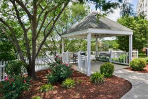 a white gazebo with a bench and a white fence at Holiday Inn Express Hotel & Suites Mooresville - Lake Norman, an IHG Hotel in Mooresville