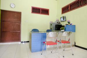 2 chaises assises à côté d'un comptoir dans une pièce dans l'établissement OYO Life 2508 Alba Suites Homestay Syariah, à Tulungagung