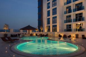 a swimming pool in front of a building at Hyatt Place Dubai Jumeirah in Dubai