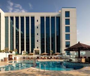 a hotel with a swimming pool and a building at Hyatt Place Dubai Jumeirah in Dubai