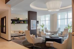 a living room with a lot of chairs and tables at Hyatt Place Dubai Jumeirah in Dubai