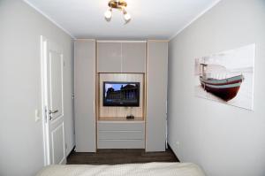 a bedroom with a bed and a tv in a room at Bellevue 02 in Laboe