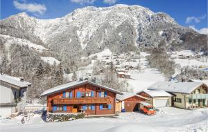 una baita di tronchi nella neve con una montagna di Stunning Apartment In Dalaas With 2 Bedrooms And Wifi a Dalaas