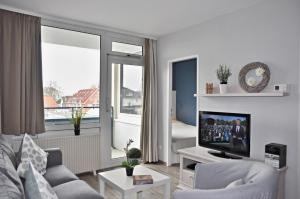 uma sala de estar com um sofá e uma televisão em Erholungszentrum Laboe HH 11 Möwennest em Laboe