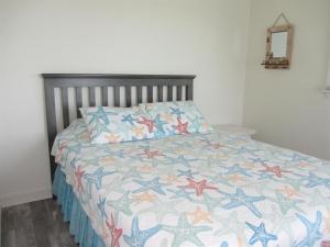 a bedroom with a bed with a quilt on it at 40310 B Due East Lane Duplex Townhouse in Avon