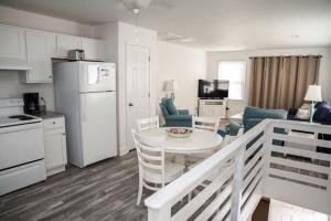 a kitchen and living room with a white table and chairs at 40310 B Due East Lane Duplex Townhouse in Avon