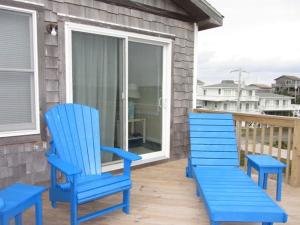 une paire de chaises bleues assises sur une terrasse couverte dans l'établissement 40310 A Due East Lane Duplex Townhouse, à Avon 6 autres photos