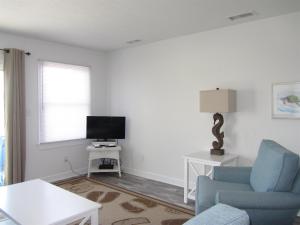 un salon avec une chaise bleue et une télévision dans l'établissement 40310 A Due East Lane Duplex Townhouse, à Avon